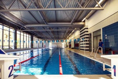 Eine große Schwimmhalle mit getrennten Bahnen und einer Aufsicht