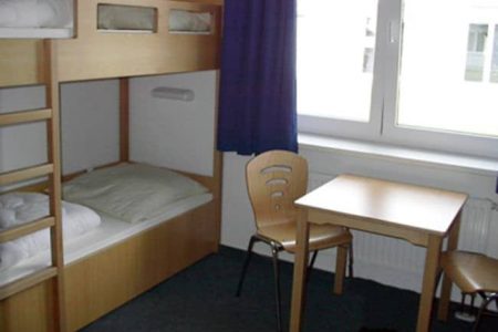 Große Zimmer mit mehreren Betten und einem Gruppentisch